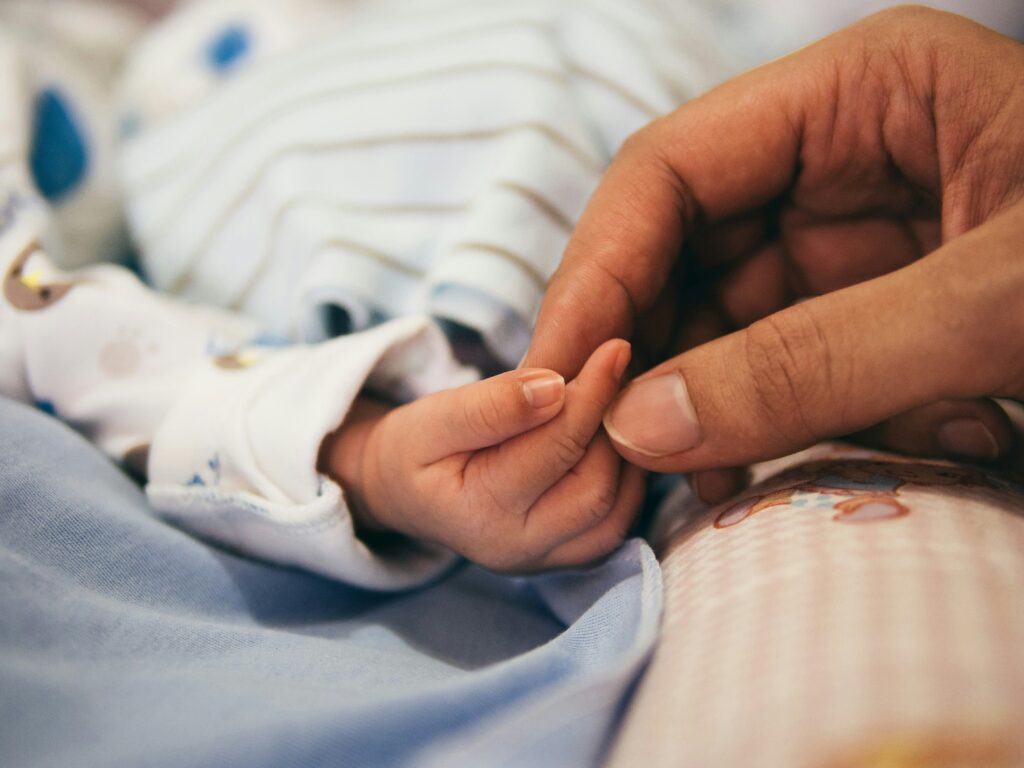mom holding baby hand having health anxiety postpartum
