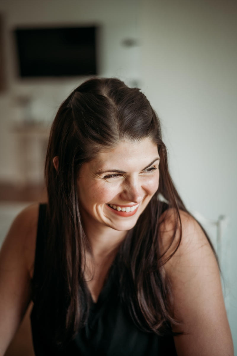 A candid shot of a smiling woman looking off to the side—reflecting the joy and openness that can come when we talk about mental health honestly and without shame.